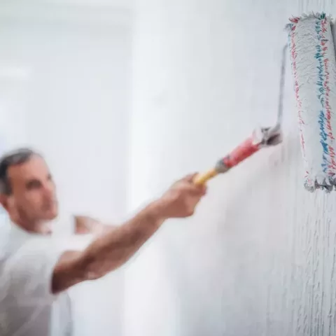 Man painting walls in home